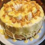 Banana Pudding Pound Cake 4 Banana Pudding Pound Cake topped with creamy banana pudding, fresh banana slices, and crushed vanilla wafers on a white serving plate.