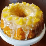 Moist pineapple cream cheese pound cake with glaze, served on a white plate