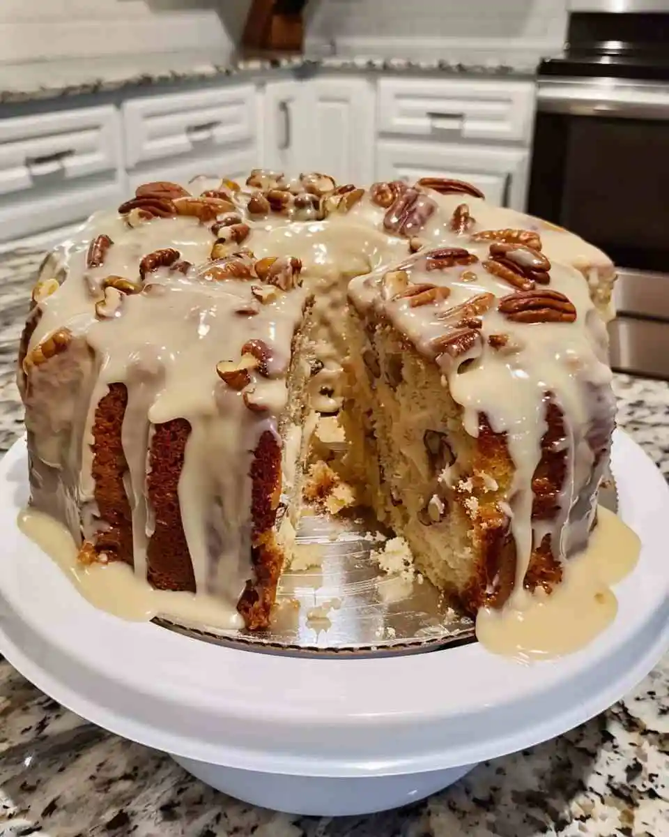 Slice of pineapple pecan cream cheese pound cake with glaze and chopped pecans on top