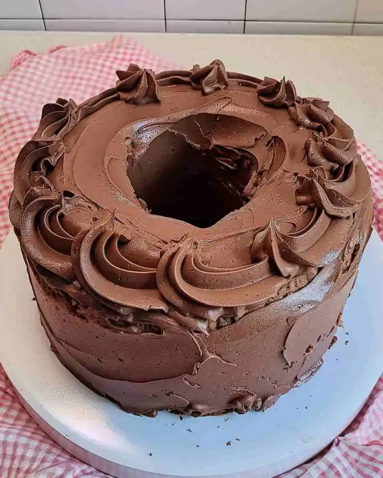 Home 15 Moist chocolate pound cake slice with rich chocolate frosting on a white plate